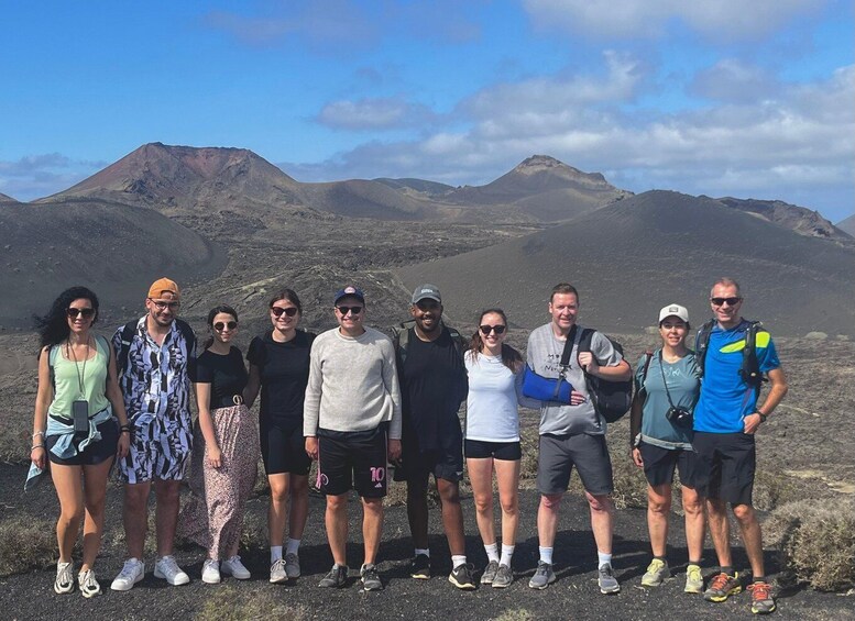 A group of people standing on a rocky terrain with mountains in the background. 4