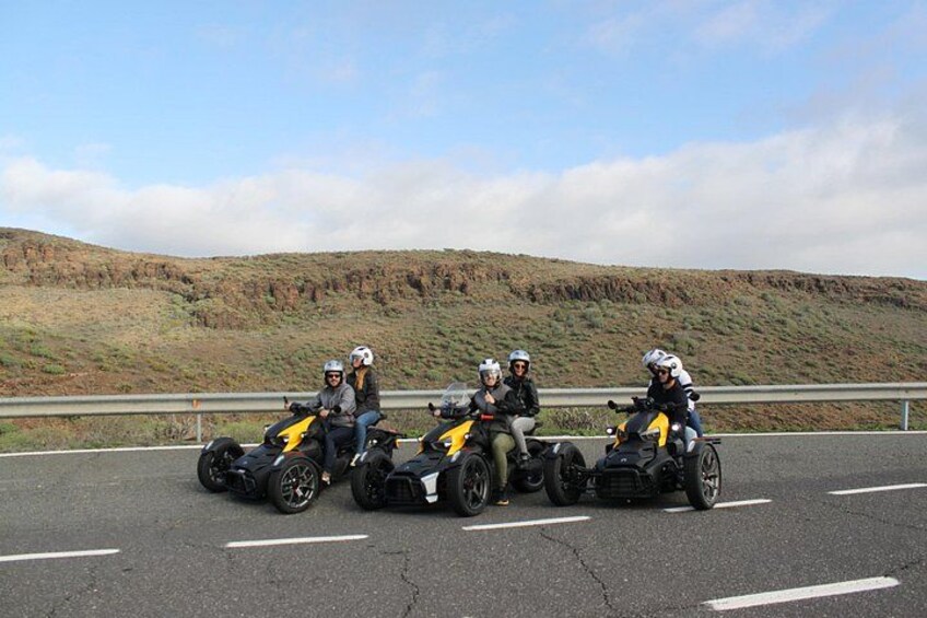 Un gruppo di persone in moto su un'autostrada con un paesaggio collinare sullo sfondo. 3