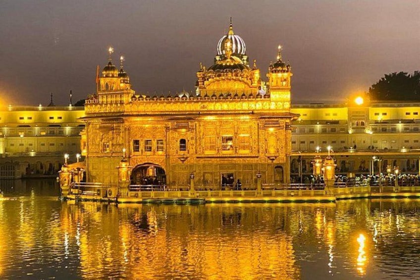 The Golden Temple at Amritsar, with its reflection in the water and surrounding buildings. 1