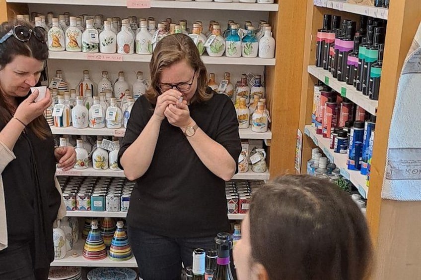 Une personne examine des bouteilles dans un magasin où de nombreuses étagères sont remplies de bouteilles et de récipients de toutes sortes. 1