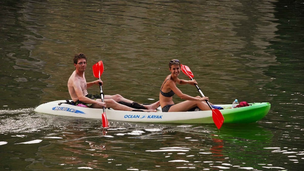 Two people kayaking on a calm river. 2