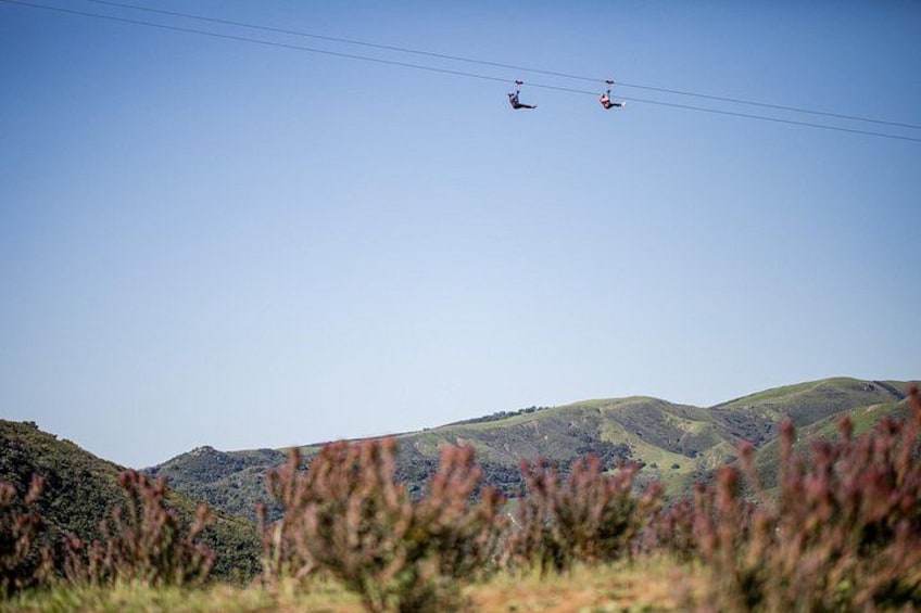 A cable car system in a mountainous area with green hills and clear skies. 5