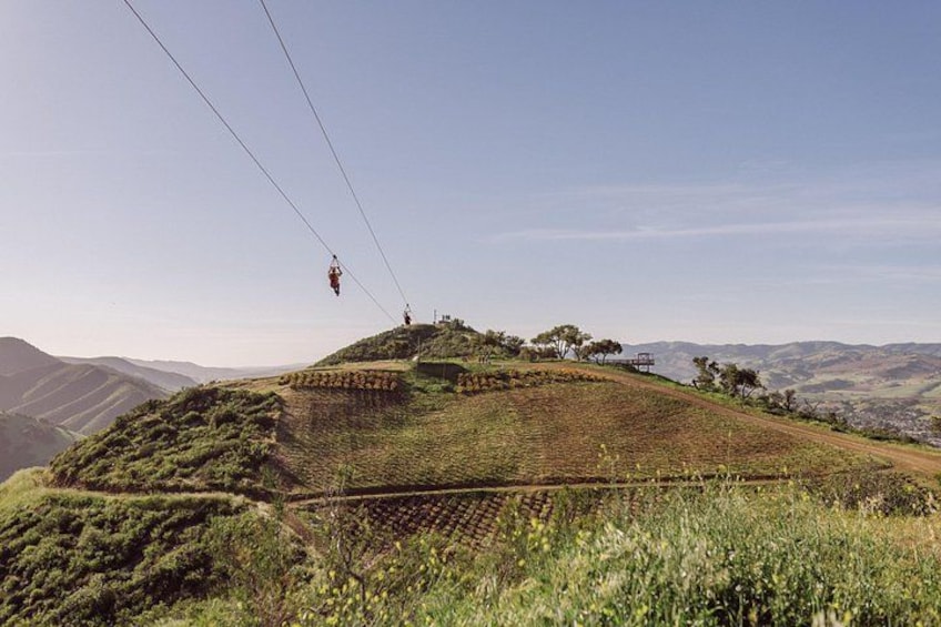 A cable car system, a hilly landscape, and distant mountains. 4