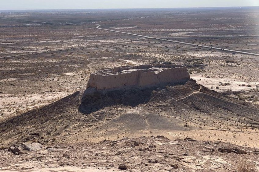 Un vasto mesa a forma di tavolo in un paesaggio desertico, con vegetazione rada e strade che si intravedono in lontananza. 2