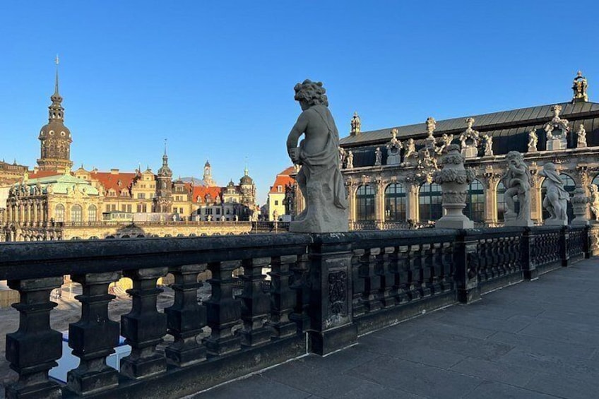 Un pont orné de statues, avec un bâtiment historique en arrière-plan. 2