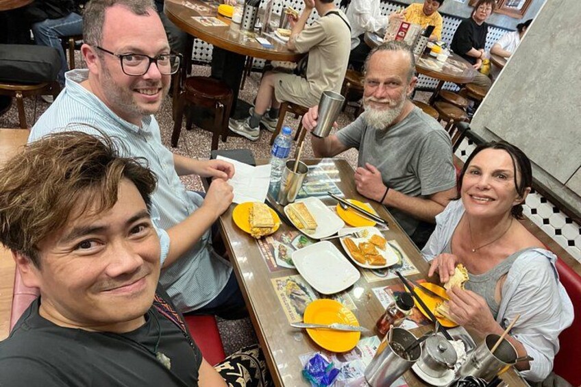 A group of people dining at a restaurant with various dishes on the table. 5