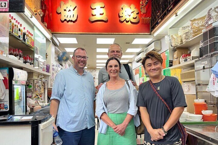A group of people in a store with shelves stocked with various products. 3