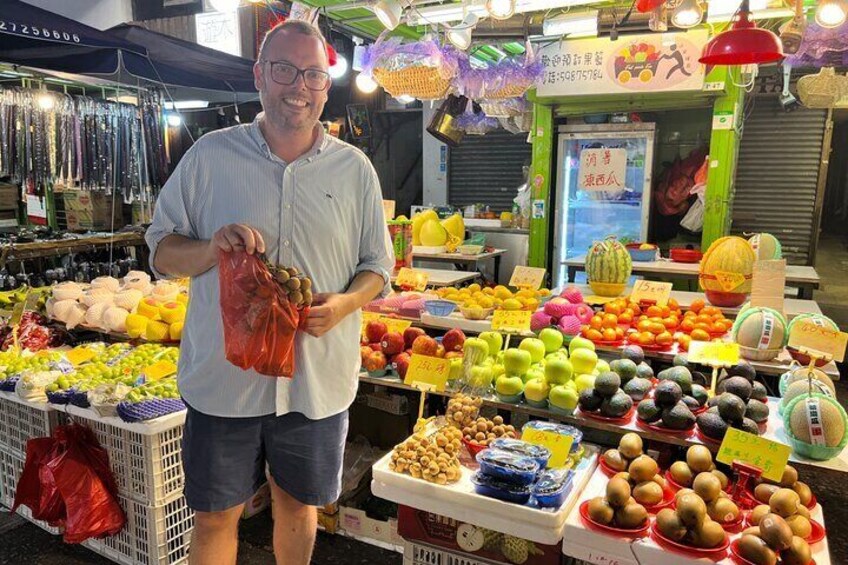 A fruit market with various fruits displayed on tables and in baskets. 4