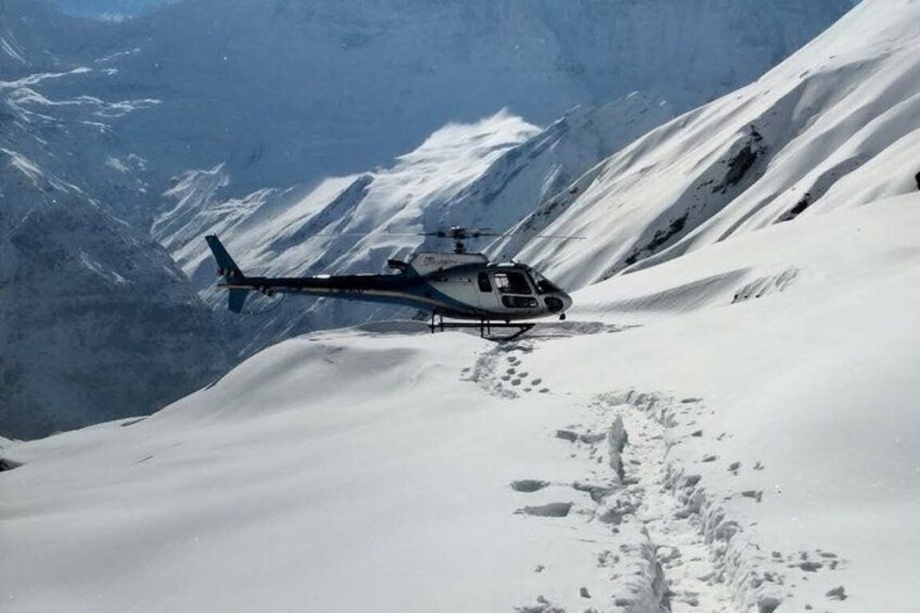 En helikopter på et snedækket bjerg. 5