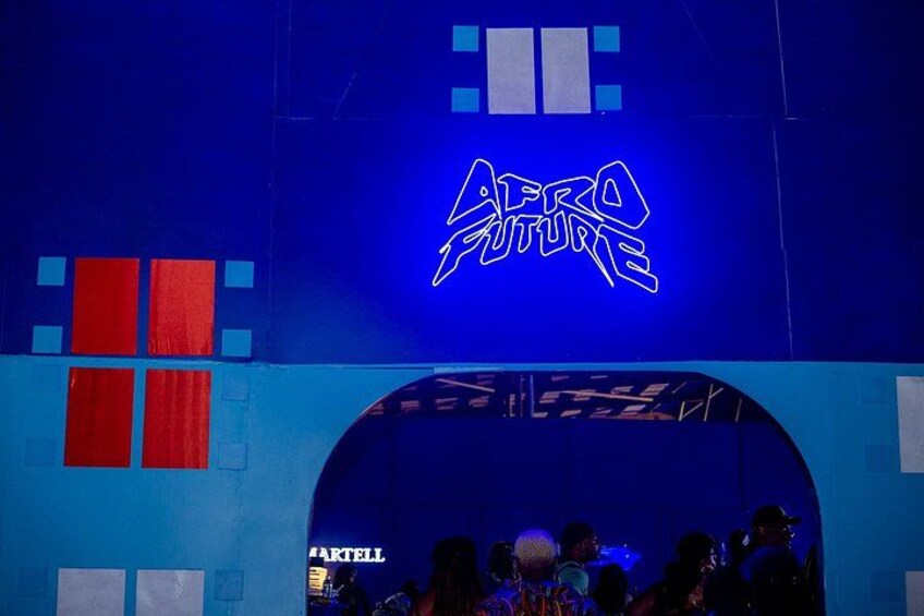 Un edificio azul con un letrero de neón que dice 'AFRO FUTURE' y un cartel con la palabra 'ARTELL' en la esquina inferior izquierda. 4