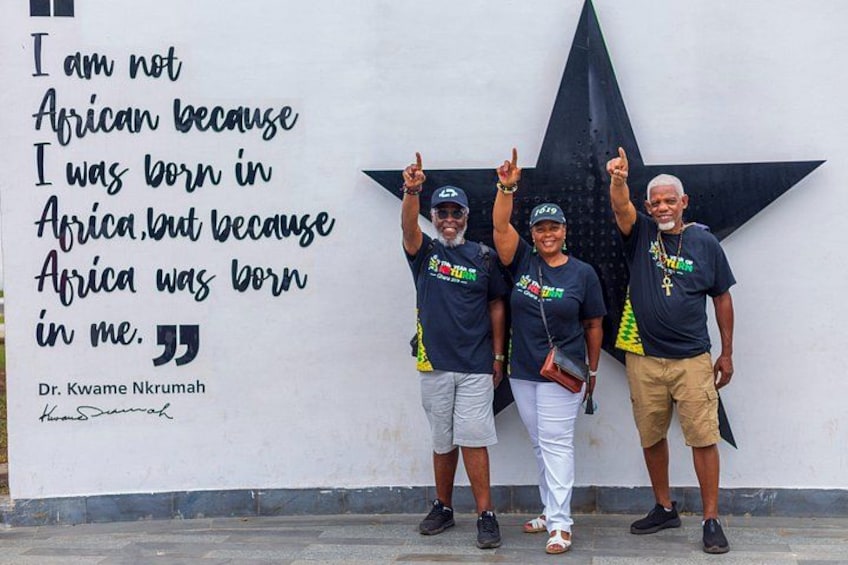 Una cita en una pared, tres personas con camisetas iguales y una gran decoración con forma de estrella. 2
