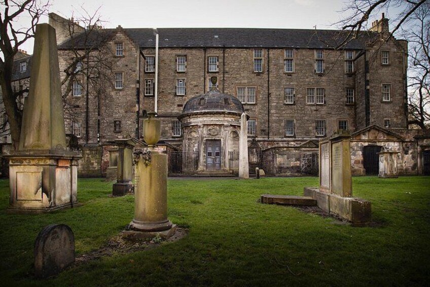 A cemetery with gravestones and a historic building in the background. 3