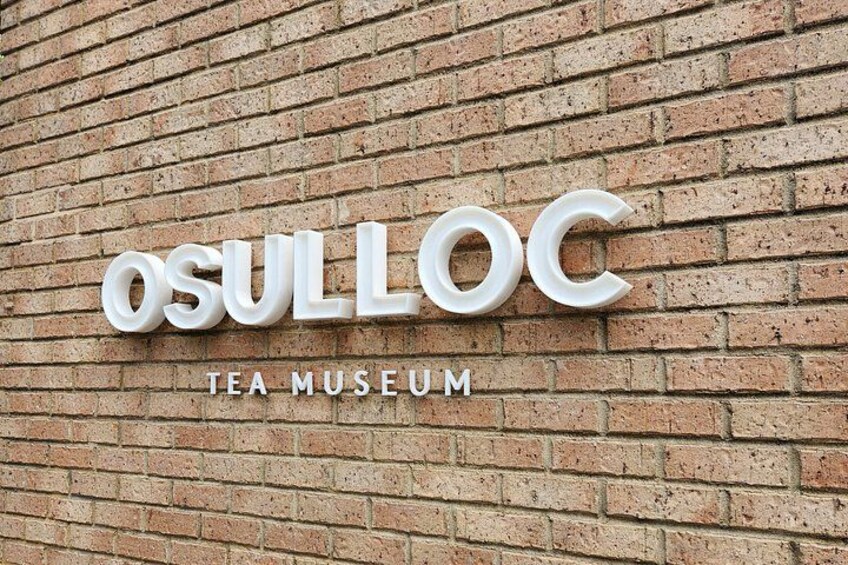 A sign for the Osulloc Tea Museum on a brick wall. 5