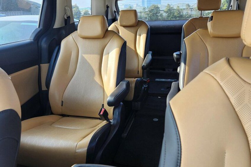 A car interior with beige leather seats and a center console. 2