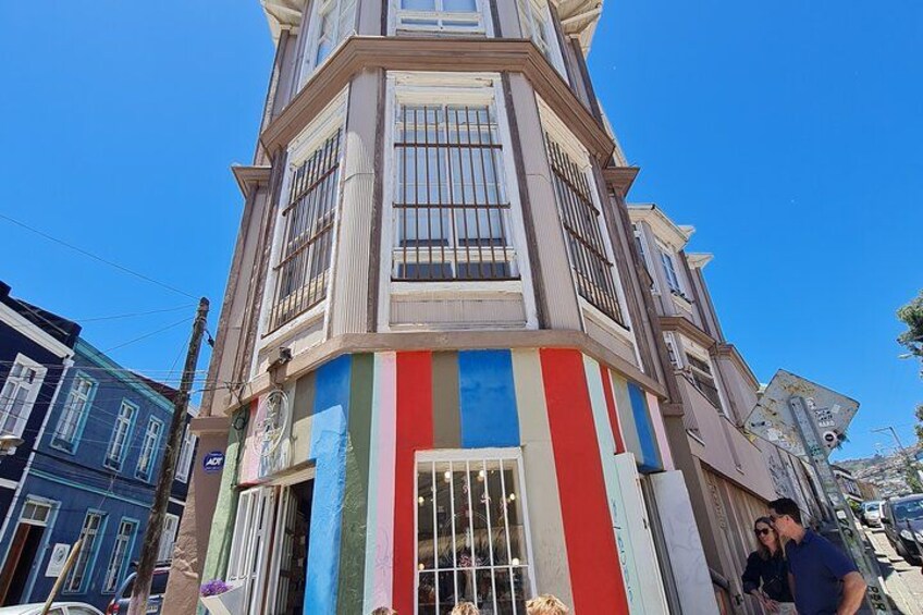 Un edificio angolare dai colori vivaci, con facciata a righe e persiane. 2