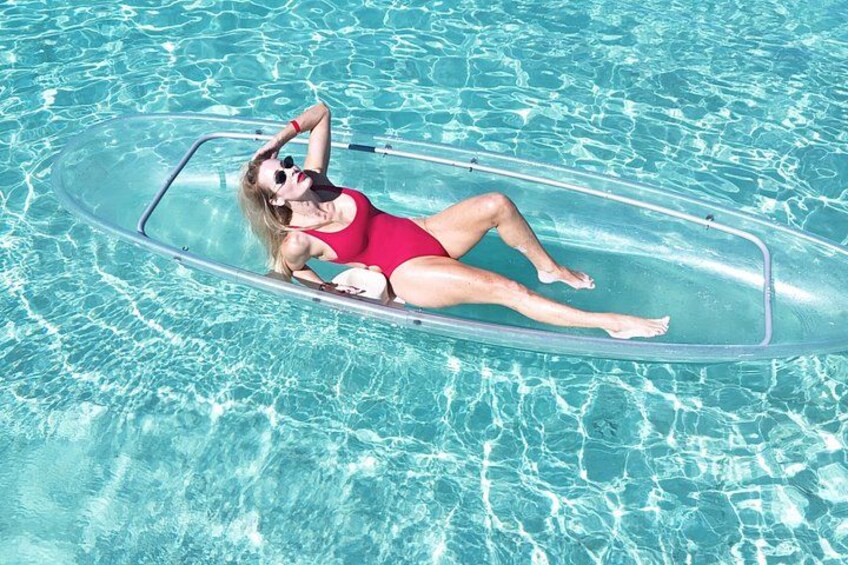A person floating on a clear inflatable raft in a pool. 5