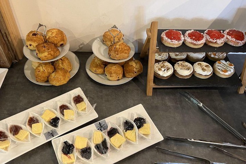 Une variété de pâtisseries est présentée, notamment des scones, des muffins et des gâteaux garnis de différentes sortes de nappages. 3