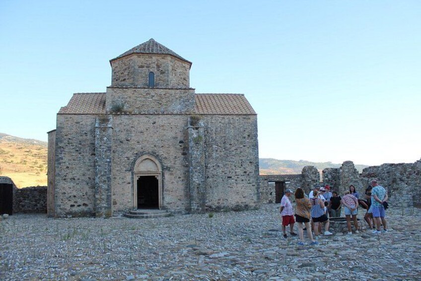 Une église en pierre dotée d’un clocher, entourée d’un groupe de personnes. 2
