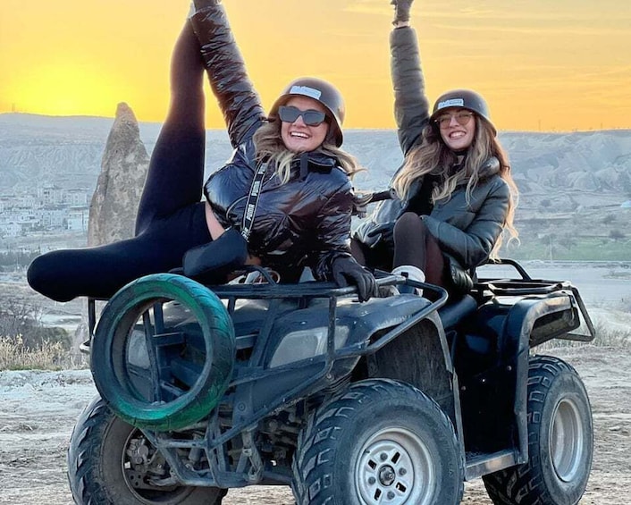 Zwei Personen fahren mit einem Quad vor einer bergigen Landschaft. 2