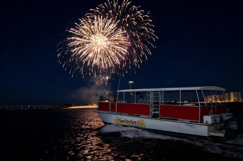Un barco en el agua con fuegos artificiales en el cielo. 1