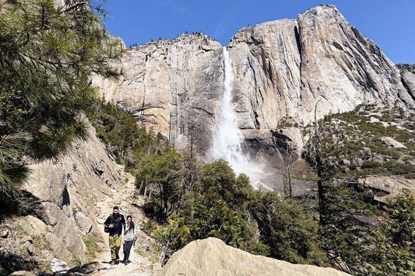 A waterfall, rocky cliffs, and hikers. 2
