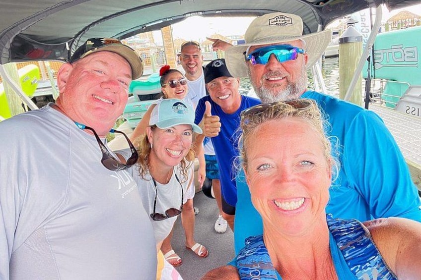 Un groupe de personnes se trouve sur un bateau doté d’un moteur vert et portant le numéro 221. 2