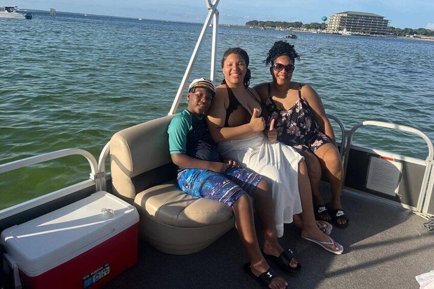 Drie personen in een boot, met een koelbox en een reling. 4