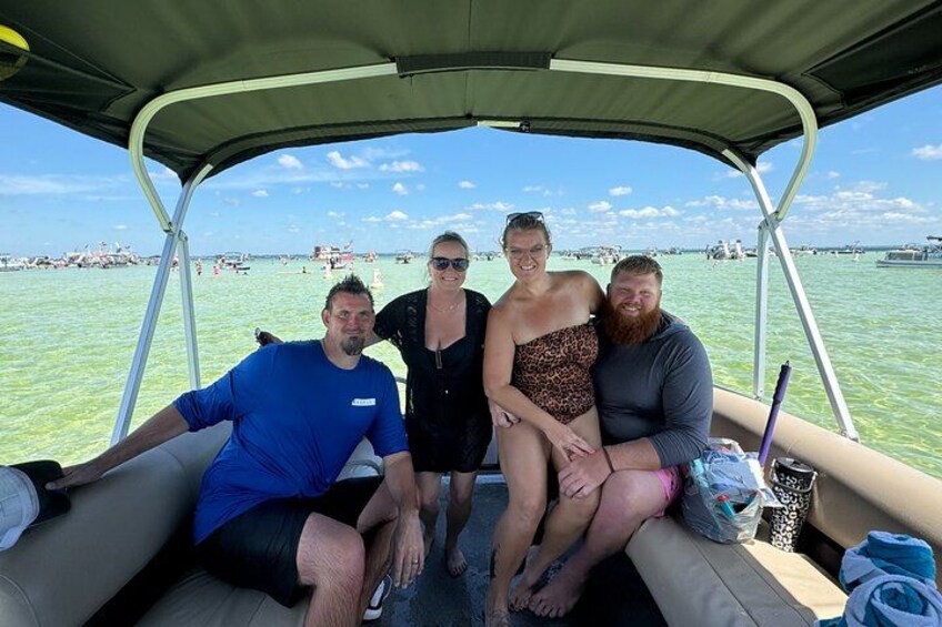 A group of people on a boat with a clear view of the water and distant boats. 3