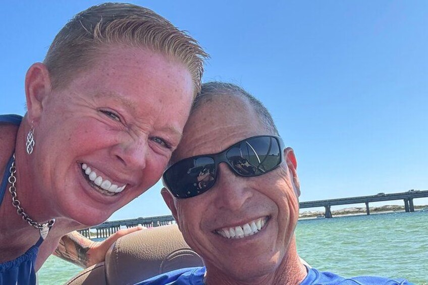 Two people on a boat with a pier in the background. 4
