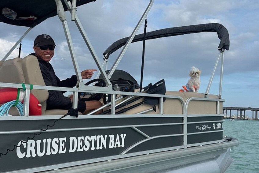 A boat with a dog and a person, a pier in the background, and a cloudy sky. 4