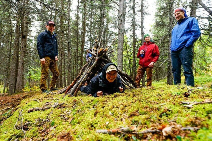 En skog med en grupp människor samlade runt ett lägerbål. 1