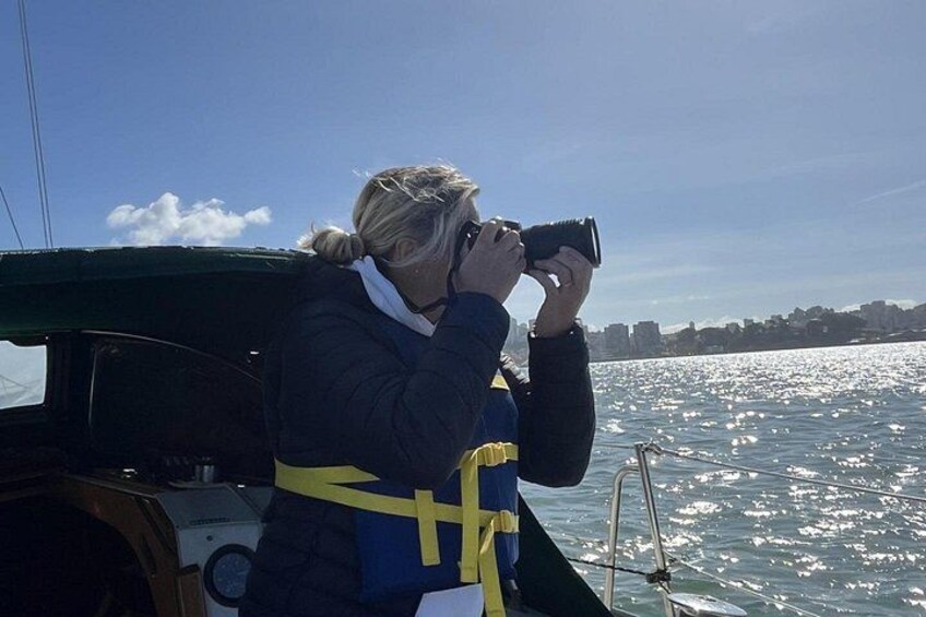 A person taking a photo with a camera on a boat. 4