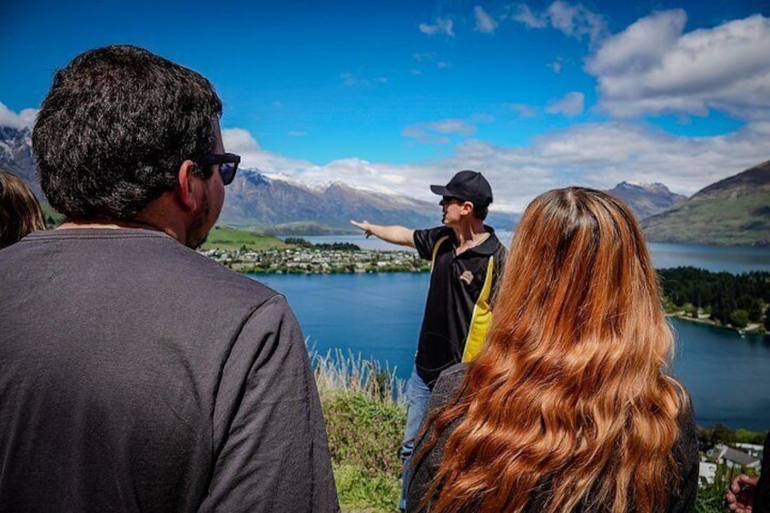 A group of people observing a lake and mountains. 5