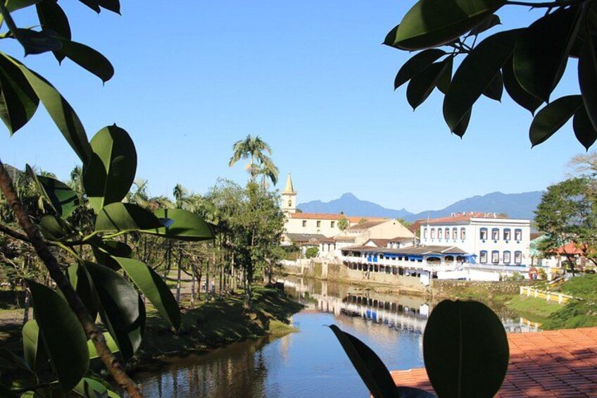 Un fiume con un ponte, edifici e montagne sullo sfondo. 3