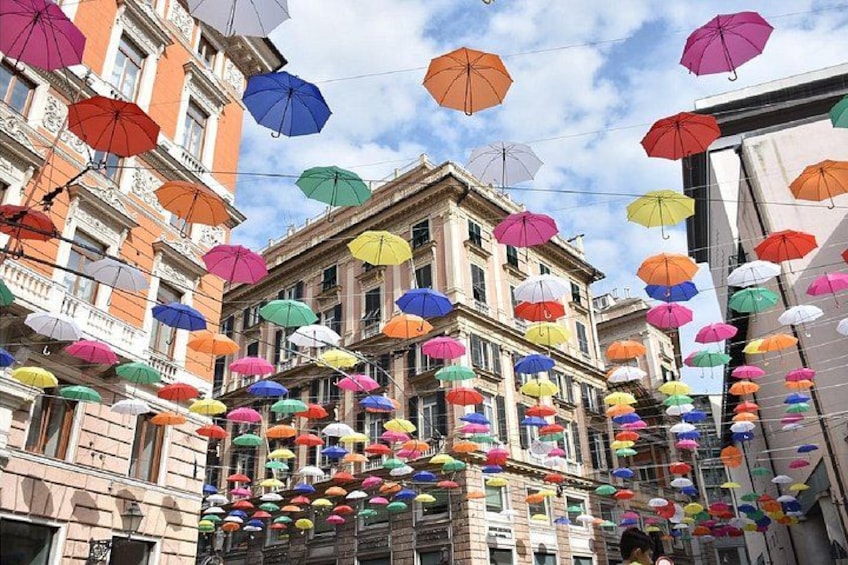 A street with colorful umbrellas hanging overhead. 2