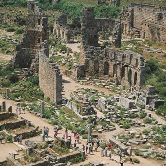 Ancient ruins with stone structures and pathways, surrounded by greenery. 3