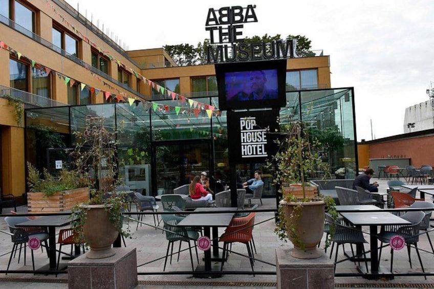 The ABBA THE MUSEUM POP HOUSE HOTEL with outdoor seating and a large screen. 1