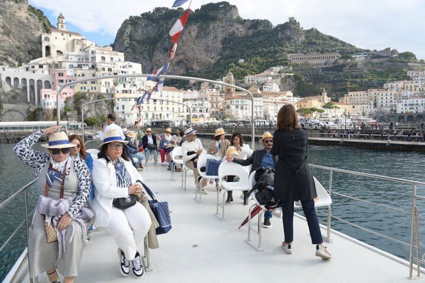 People on a boat with a coastal town in the background. 2