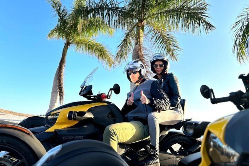 Dos personas en un cuatrimoto amarillo, con palmeras al fondo. 5