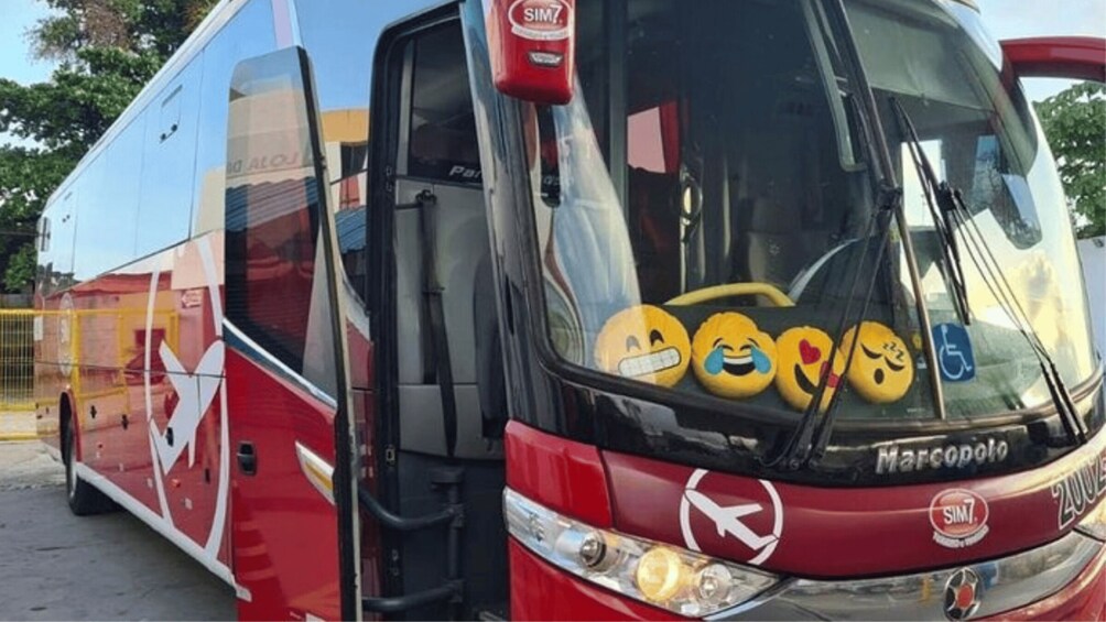 Un autobús rojo y azul con el logotipo de SIM7 y una pegatina con el logotipo de SIM7 en el parabrisas. 2