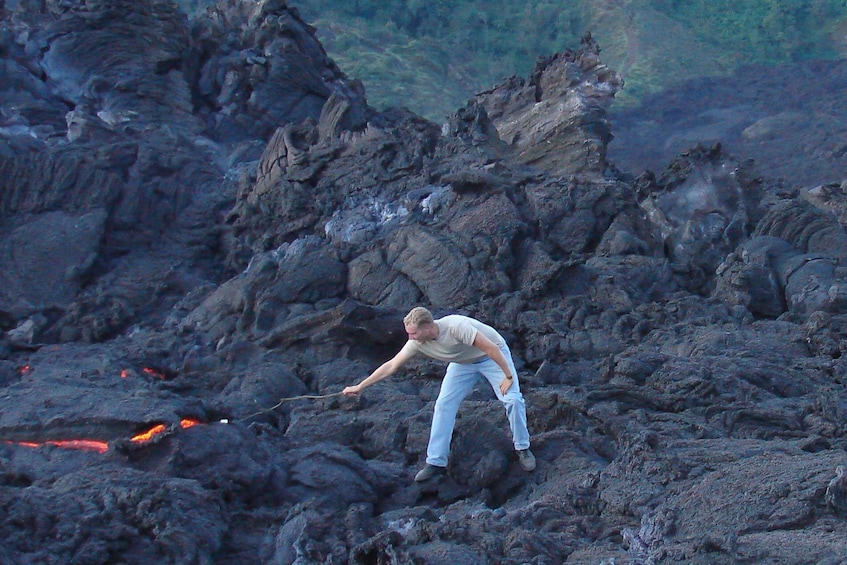 A person navigating a rocky terrain with flowing lava. 1