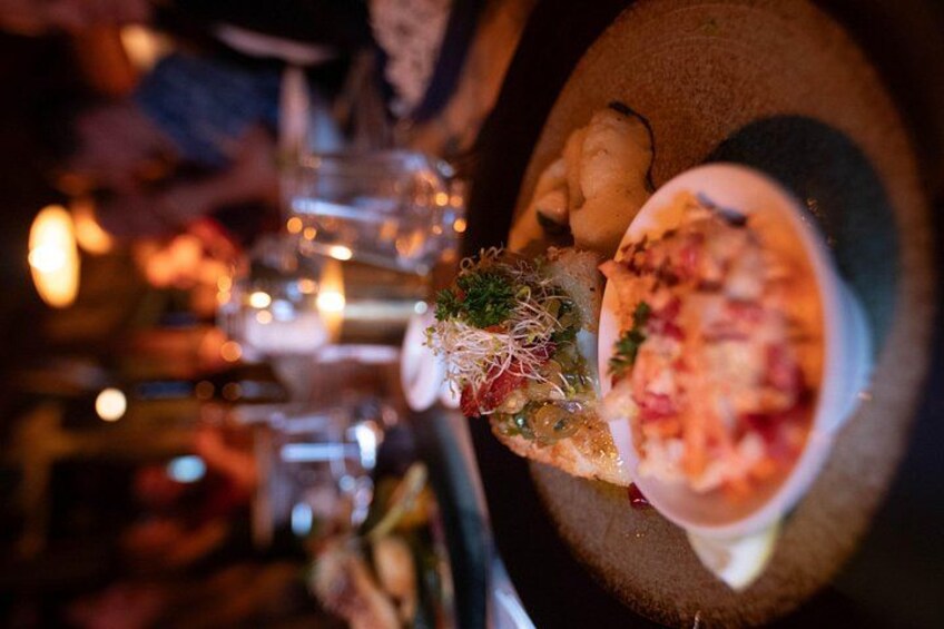 A dining table with a plate of food, a glass of water, and a candle. 2