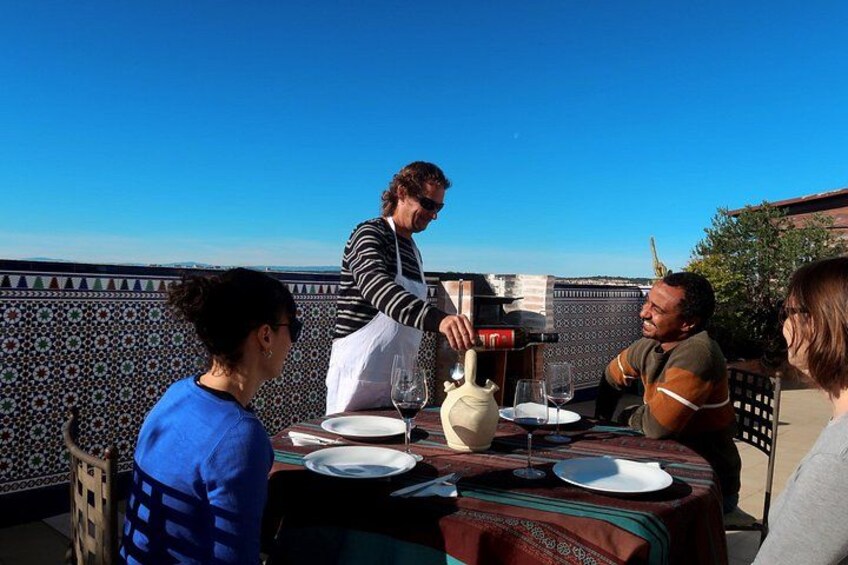 A person serving food at an outdoor table with a clear blue sky in the background. 5