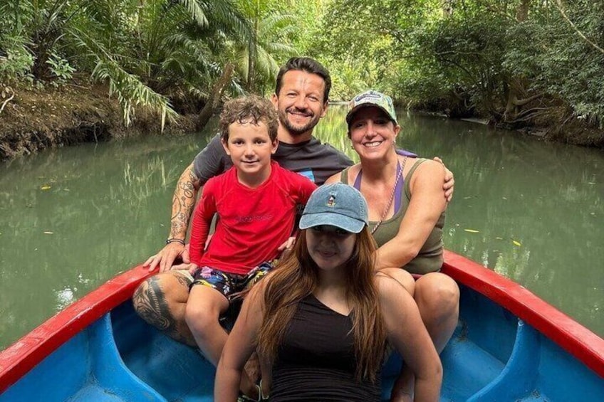 A family in a small boat on a river surrounded by dense greenery. 1
