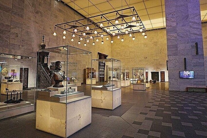 Un museo en interiores con vitrinas de vidrio, una estatua grande y un diseño de techo moderno. 3