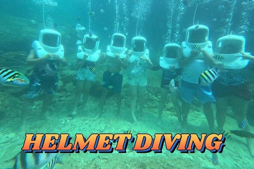 Menschen mit Helmen unter Wasser, umgeben von Fischen, mit dem Text 'HELMET DIVING'. 2