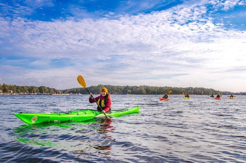 A person kayaking on a calm lake with a forested shoreline in the background. 5