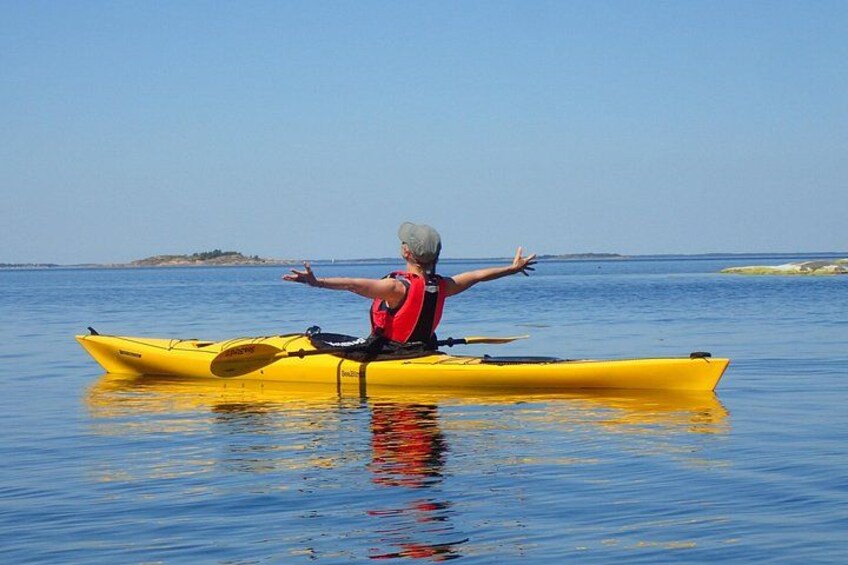 A person in a yellow kayak on calm water with a clear sky. 1