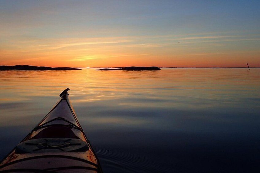 A kayak on calm water during sunset with a clear sky. 4