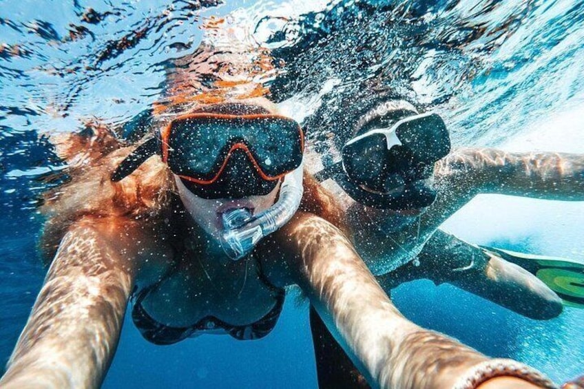 A person underwater with snorkel and fins, swimming in clear blue water. 1